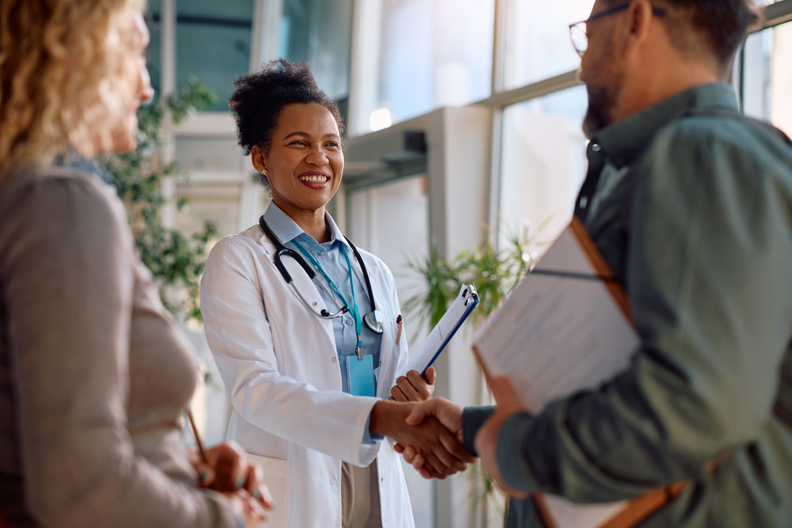 Happy,African,American,Doctor,Greeting,A,Man,Who,Came,With