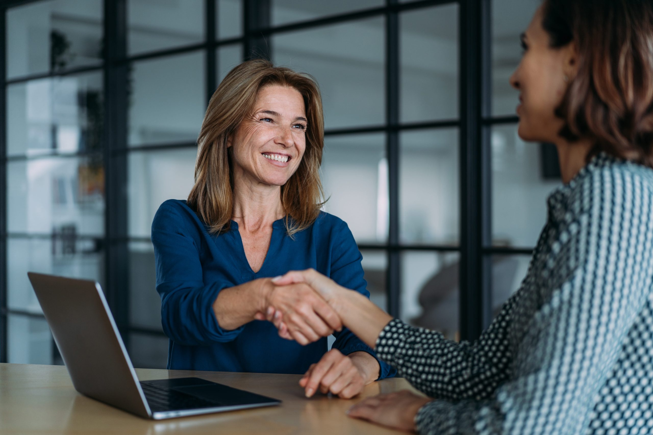 businesswoman-handshake-client-agreement-office-wolf-and-company